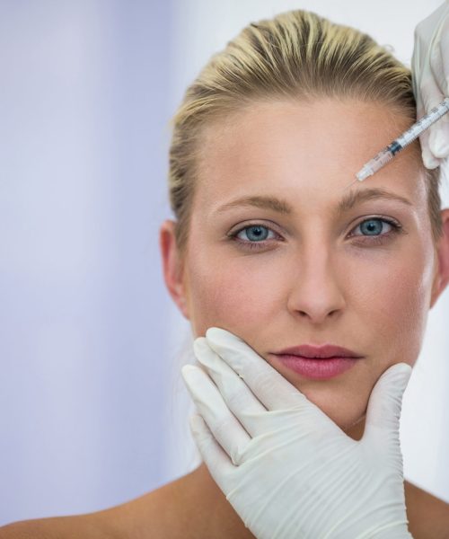 Close-up of female patient receiving a botox injection on forehead